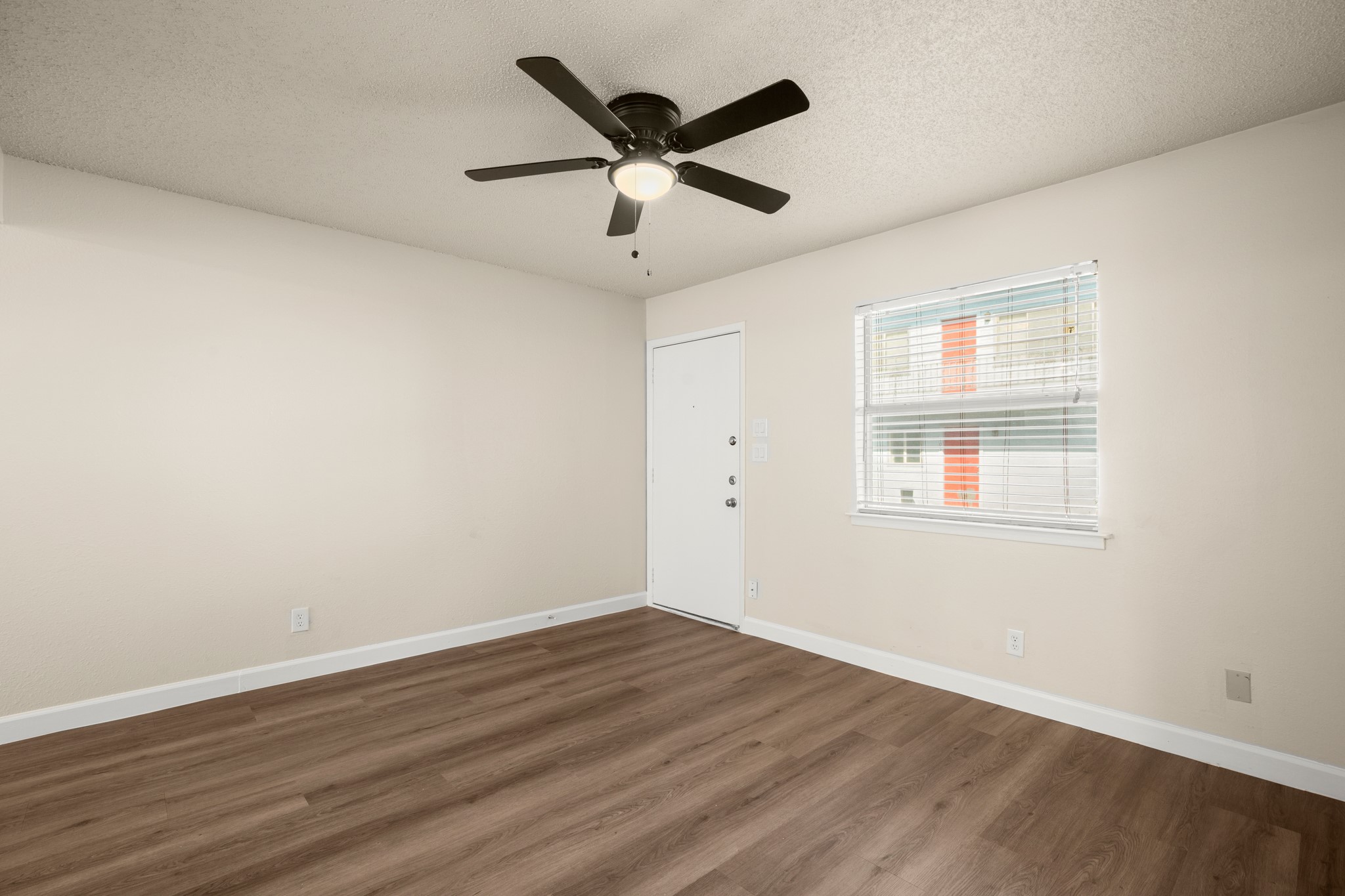 2408 Longview Street, Unit 112 Austin, TX 78705 - Photo 9 of 15 an empty room with wooden floor and ceiling fan