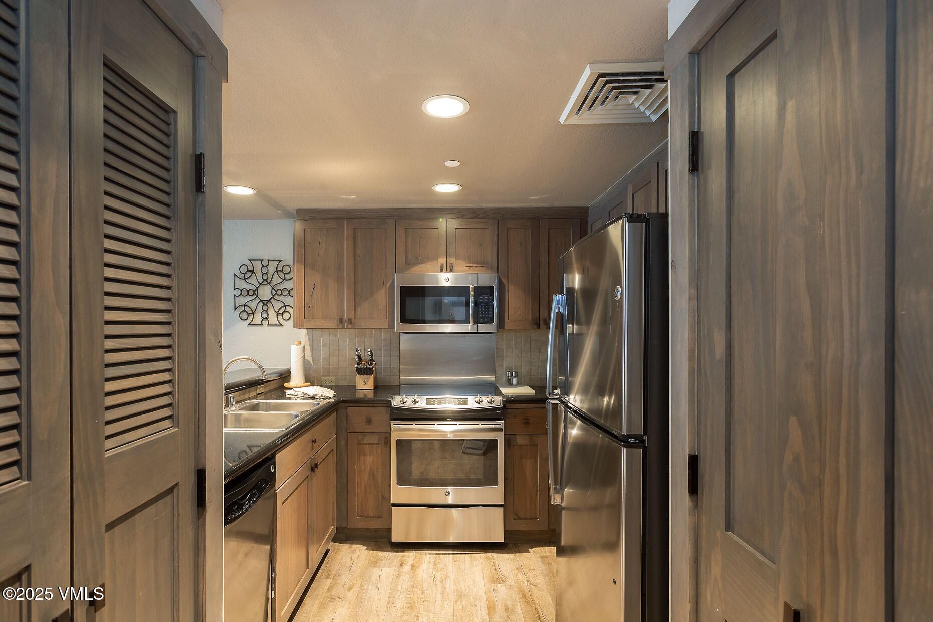 210 Offerson Road, Unit 3044 Beaver Creek, CO 81620 - Photo 5 of 21 a kitchen with stainless steel appliances a refrigerator and a stove top oven