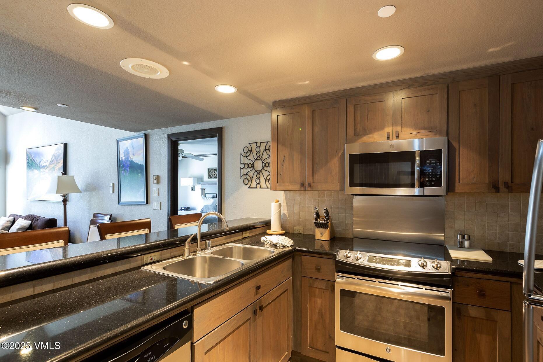 210 Offerson Road, Unit 3044 Beaver Creek, CO 81620 - Photo 6 of 21 a kitchen with stainless steel appliances a sink stove and microwave