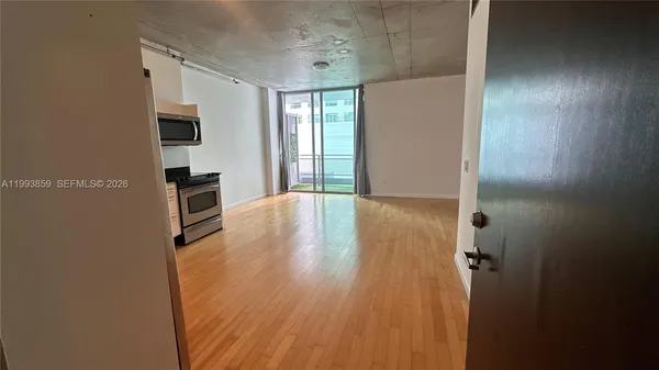 a view of a kitchen with wooden floor and electronic appliances