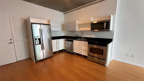a kitchen with stainless steel appliances granite countertop a stove a microwave and a refrigerator