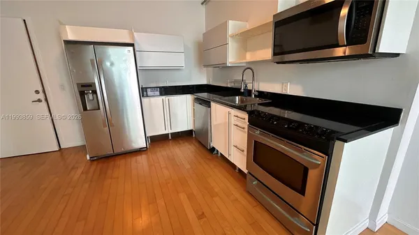 a kitchen with stainless steel appliances a refrigerator sink and microwave