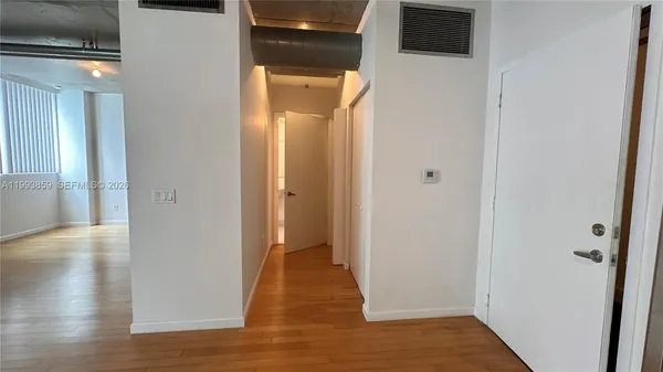 a view of a hallway with wooden floor