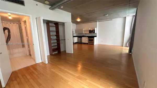 an empty room with wooden floor and balcony