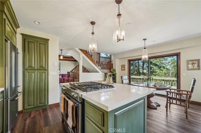 a kitchen that has a table chairs and a wooden floor