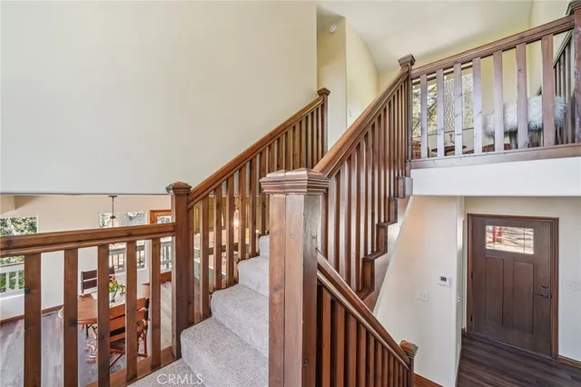a view of staircase with lots of frames on wall and wooden floor