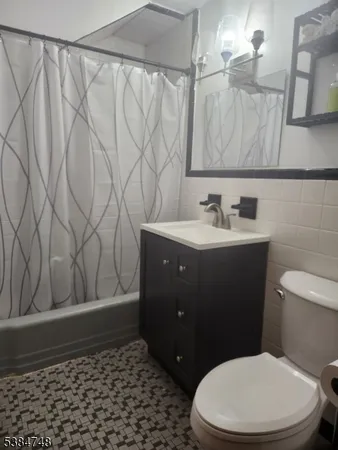 a bathroom with a toilet a sink and a shower curtain