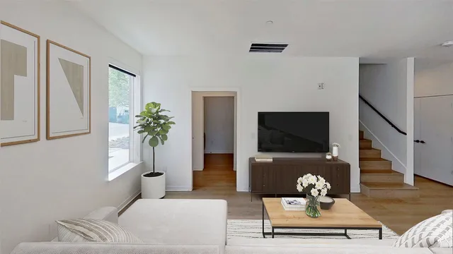 a living room with furniture a flat screen tv and a potted plant