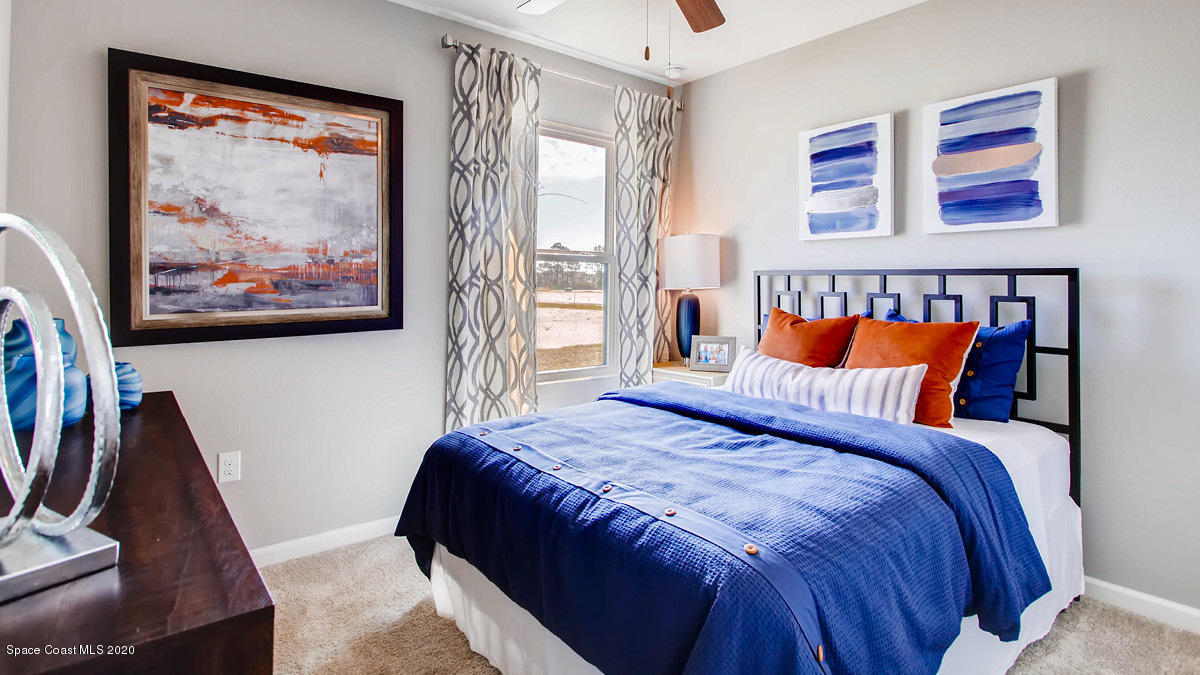 578 Old Country Rd S East Palm Bay, FL 32909 - Photo 9 of 26 a bed sitting in a bedroom next to a window