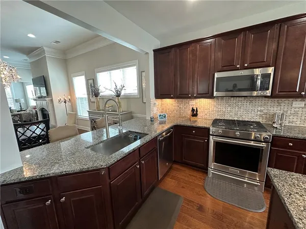 a kitchen with stainless steel appliances granite countertop a sink stove and refrigerator