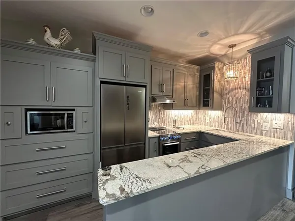 a bathroom with a granite countertop sink a mirror and a shower