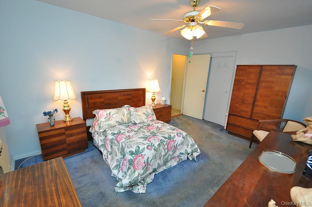 682 Tuckahoe Road, Unit 5H Yonkers, NY 10710 - Photo 14 of 24 a bedroom with a bed and a chandelier