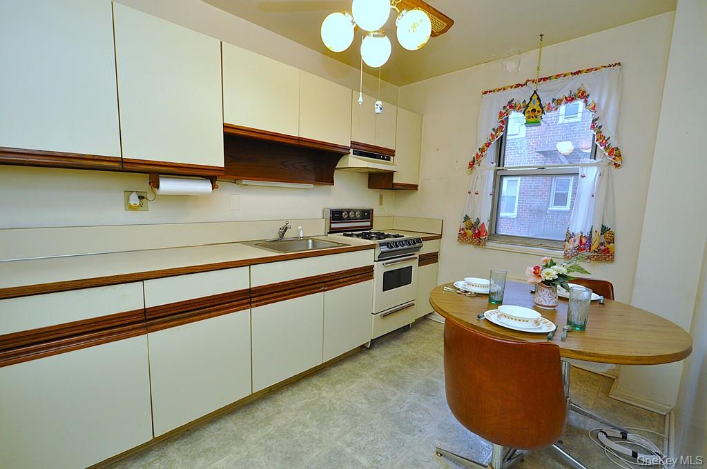 682 Tuckahoe Road, Unit 5H Yonkers, NY 10710 - Photo 8 of 24 a kitchen with stainless steel appliances granite countertop a sink a stove and a wooden floors
