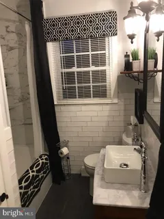 a bathroom with a sink toilet and window