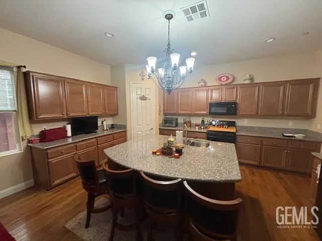 a kitchen with kitchen island granite countertop a sink a center island and cabinets