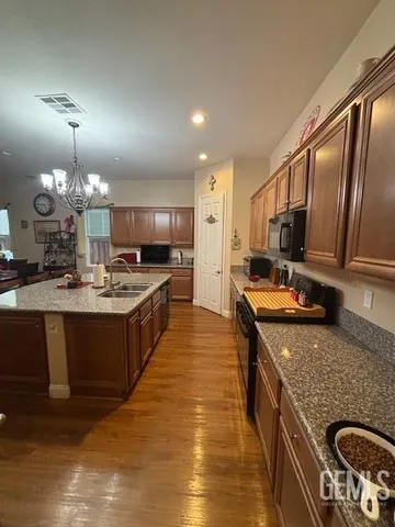 a large kitchen with a stove and a chandelier