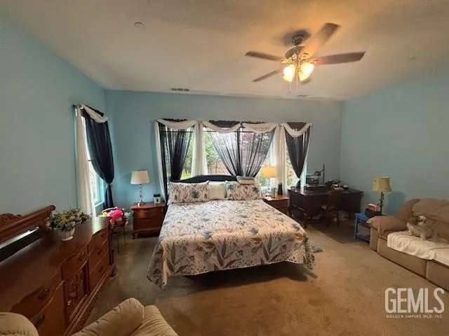 a bedroom with a bed chandelier and window