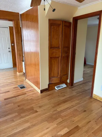 an empty room with wooden floor and a window