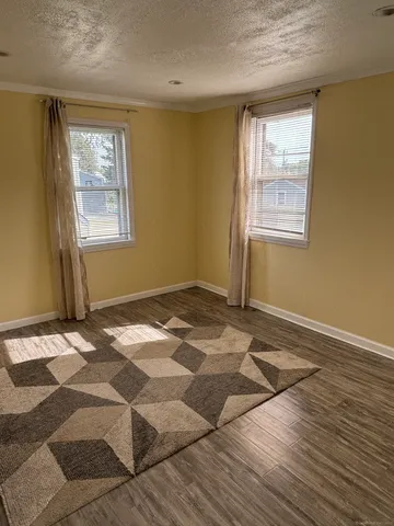 a view of a livingroom with wooden floor and window