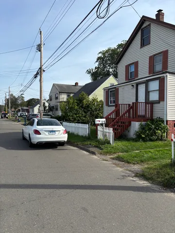 a white house covered with tall trees