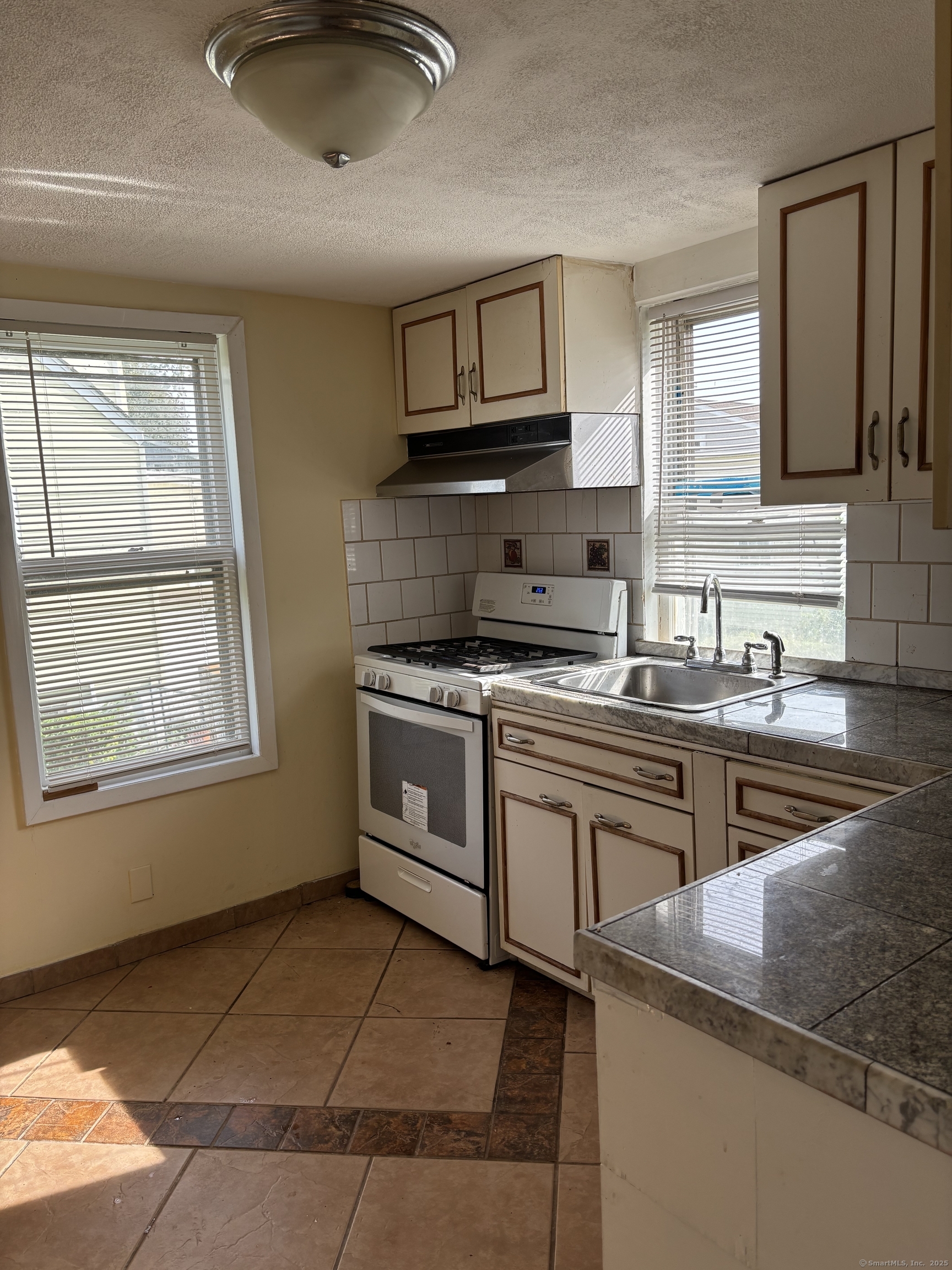 15 Harding Avenue Stratford, CT 06615 - Photo 6 of 38 a kitchen with stainless steel appliances granite countertop a sink stove and cabinets