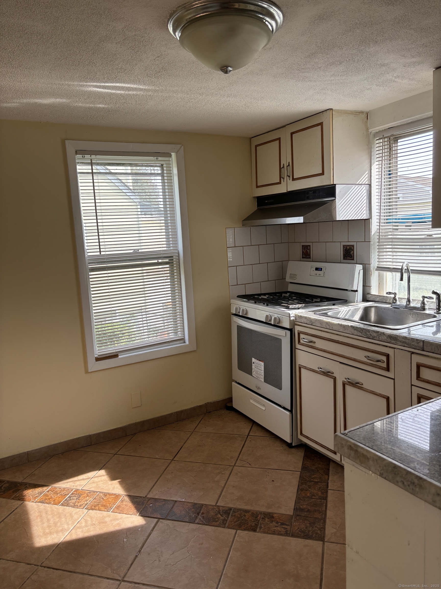 15 Harding Avenue Stratford, CT 06615 - Photo 8 of 38 a kitchen with stainless steel appliances granite countertop a stove a sink and a microwave