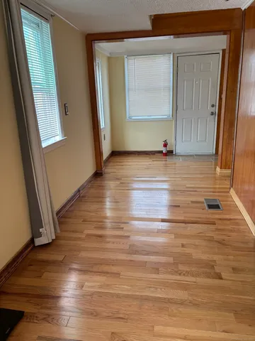a view of empty room with window and wooden floor