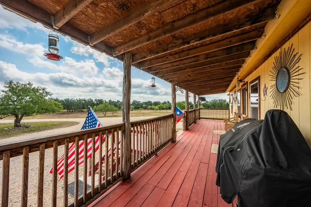 a dining room with stainless steel appliances kitchen island granite countertop a table chairs and wooden floor