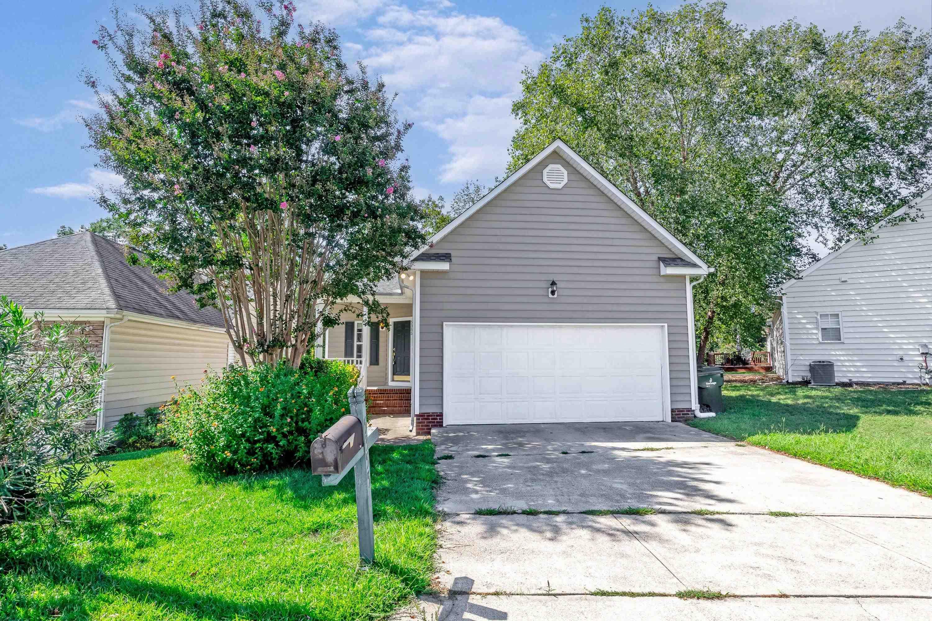 a front view of house with yard and trees all around