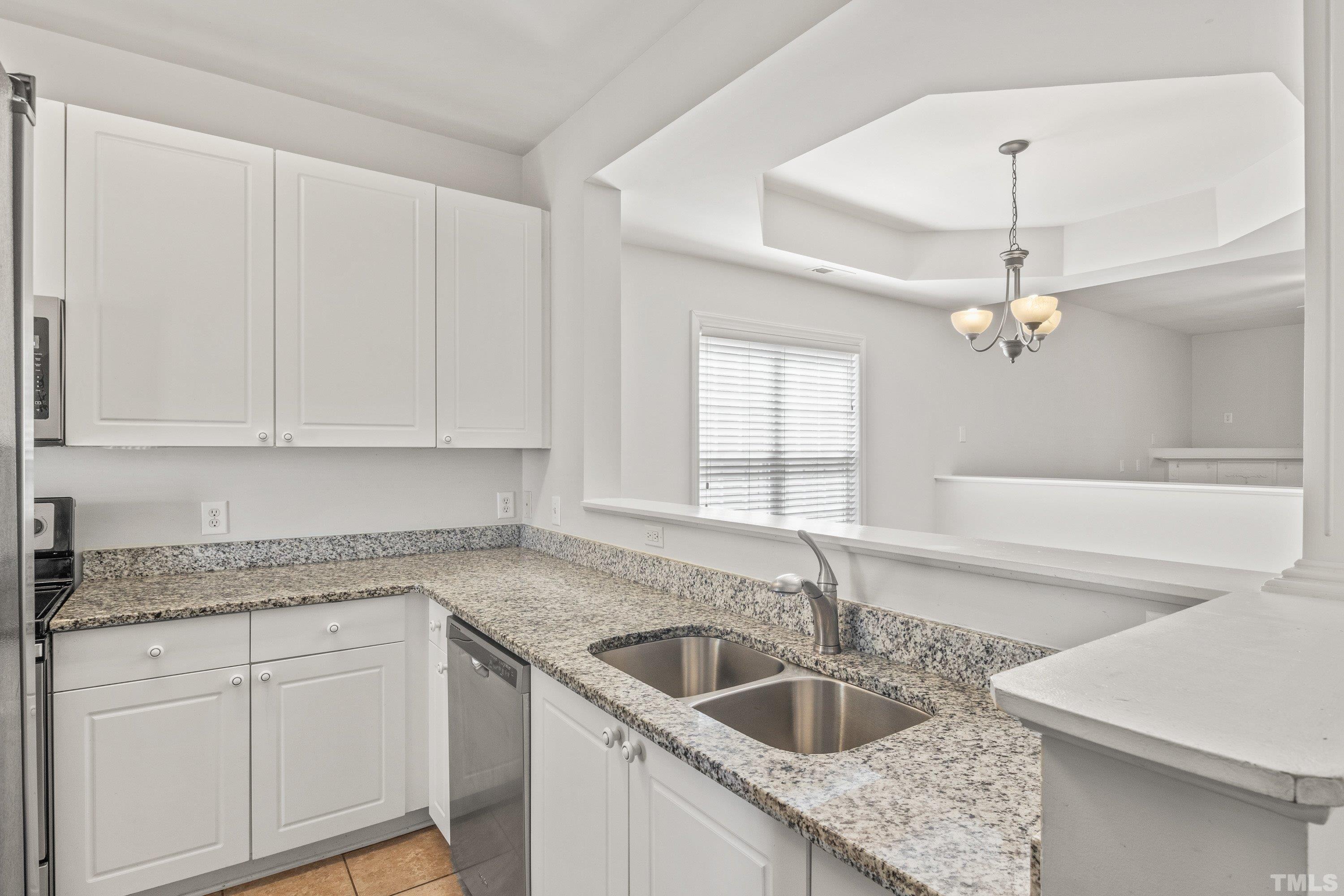 5355 Sahalee Way Raleigh, NC 27604 - Photo 15 of 42 a kitchen with granite countertop a sink and white cabinets