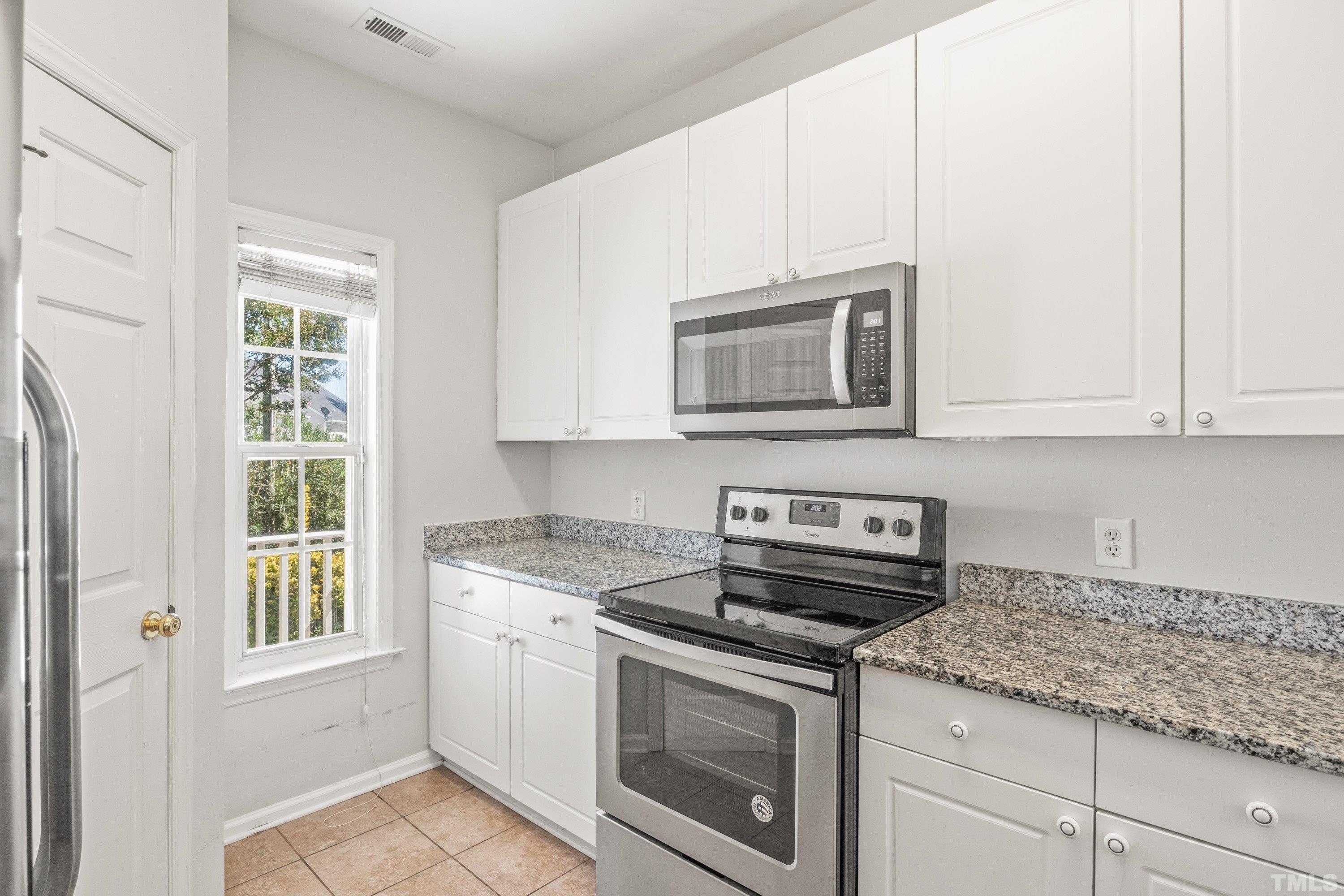 5355 Sahalee Way Raleigh, NC 27604 - Photo 16 of 42 a kitchen with granite countertop white cabinets stainless steel appliances and a window