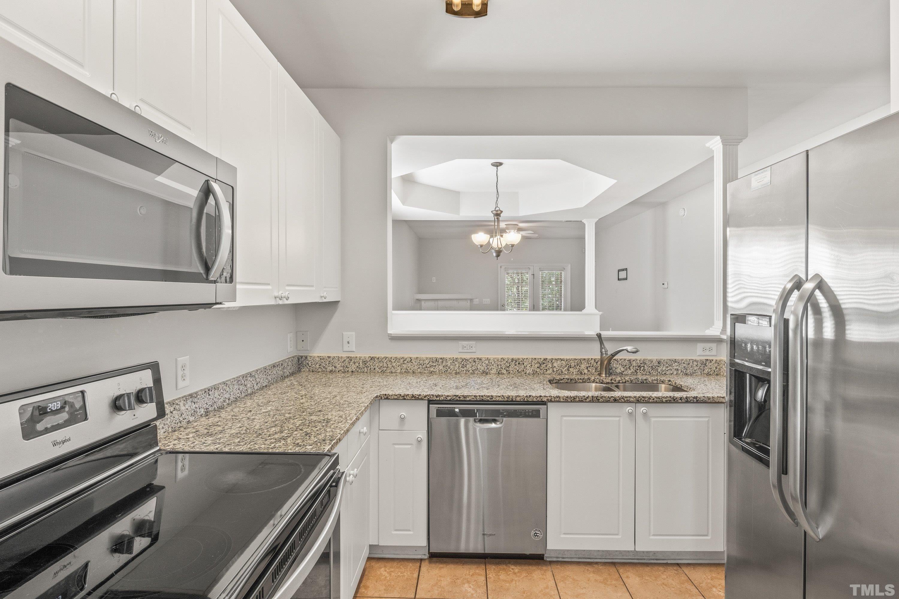 5355 Sahalee Way Raleigh, NC 27604 - Photo 18 of 42 a kitchen with stainless steel appliances granite countertop a sink and a refrigerator