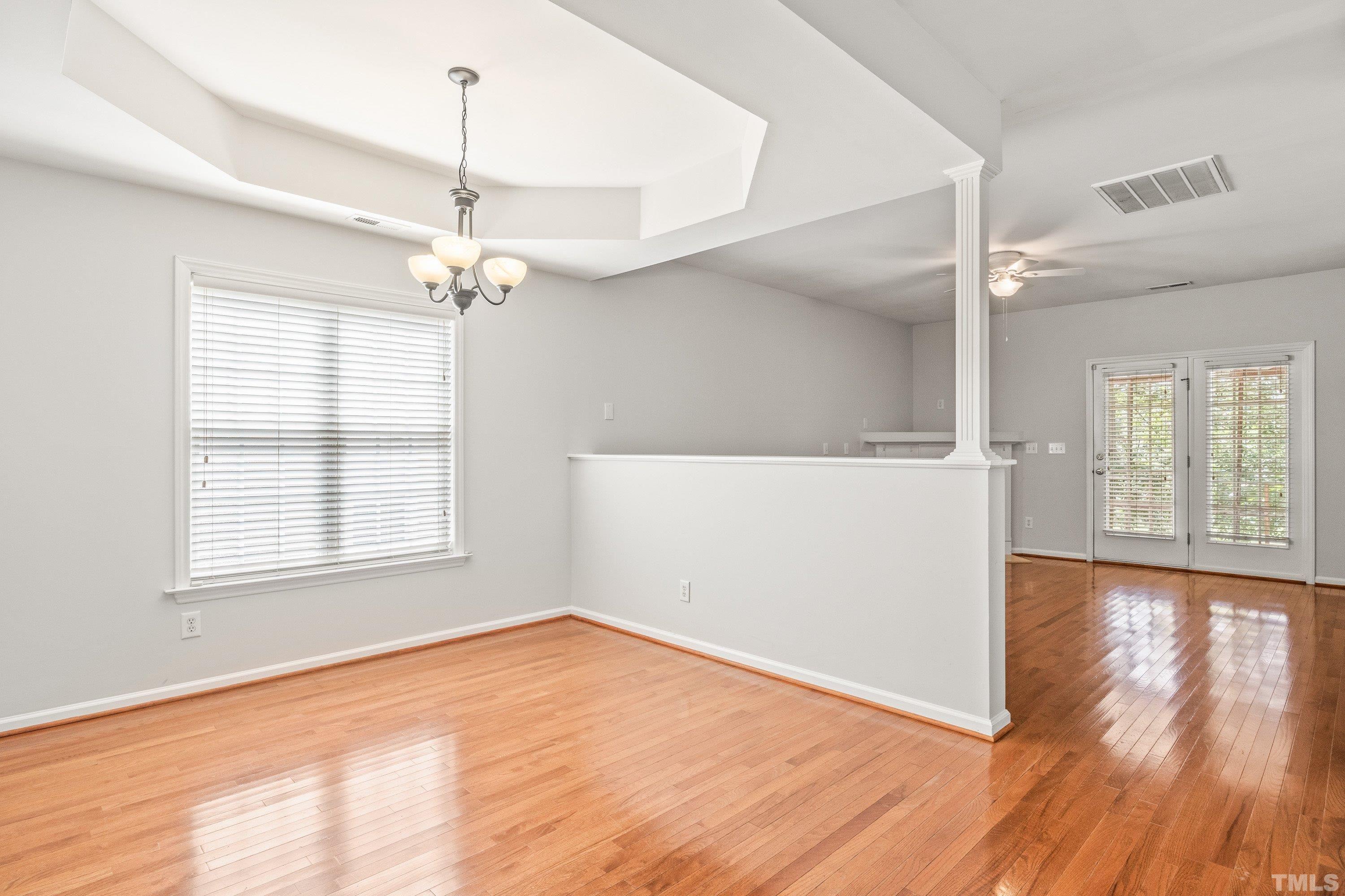 5355 Sahalee Way Raleigh, NC 27604 - Photo 20 of 42 an empty room with wooden floor chandelier and windows