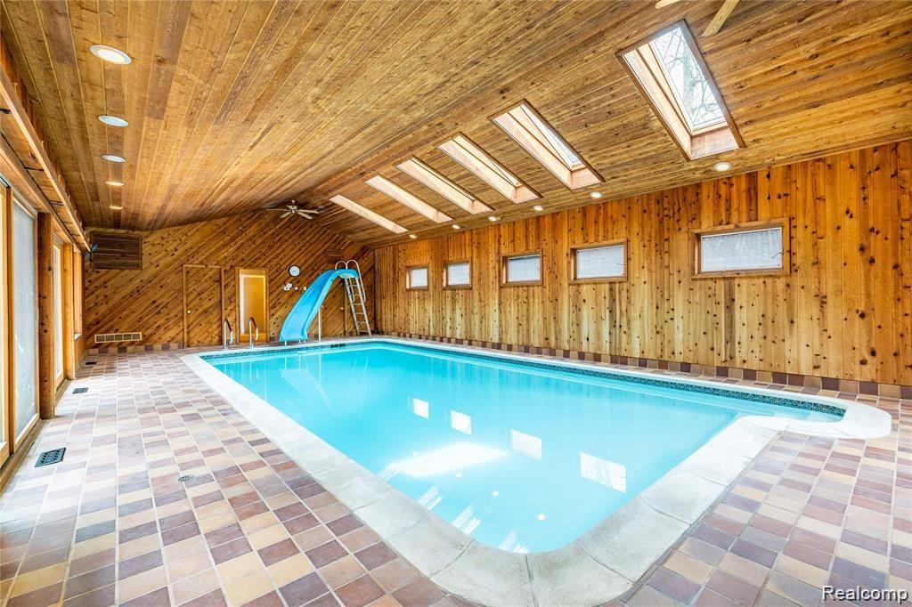 19130 Meridian Road Grosse Ile, MI 48138 - Photo 22 of 49 Huge rec room houses a large in-ground pool with slide.