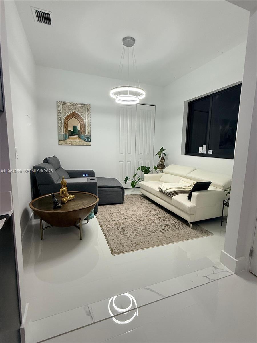 15455 Southwest 232nd Street, Unit A Miami, FL 33170 - Photo 1 of 12 a living room with furniture and a flat screen tv