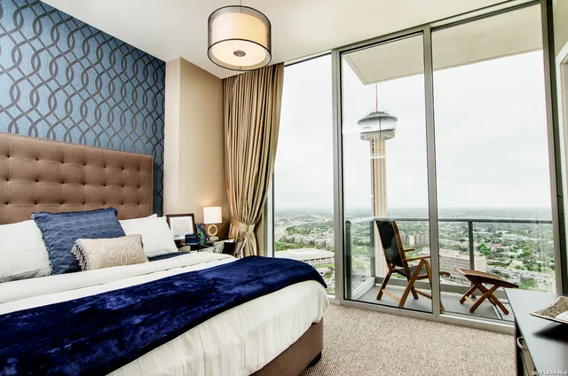 a bedroom with a bed and large windows