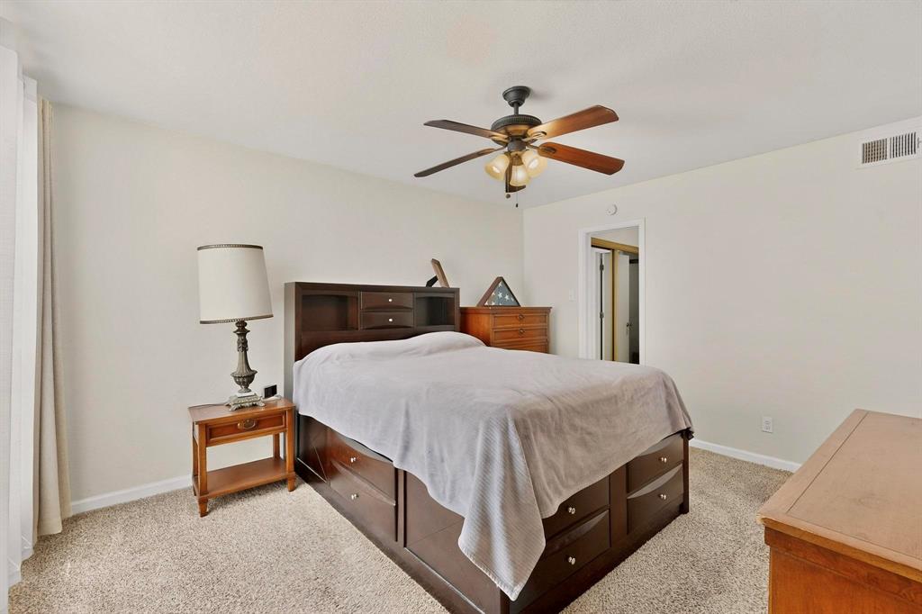 5981 Arapaho Road, Unit 901 Dallas, TX 75248 - Photo 25 of 38 a bedroom with a bed and a chandelier