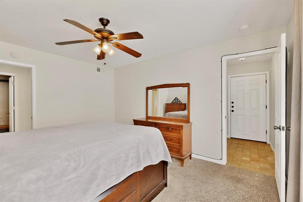 5981 Arapaho Road, Unit 901 Dallas, TX 75248 - Photo 26 of 38 a bedroom with a bed and a chandelier