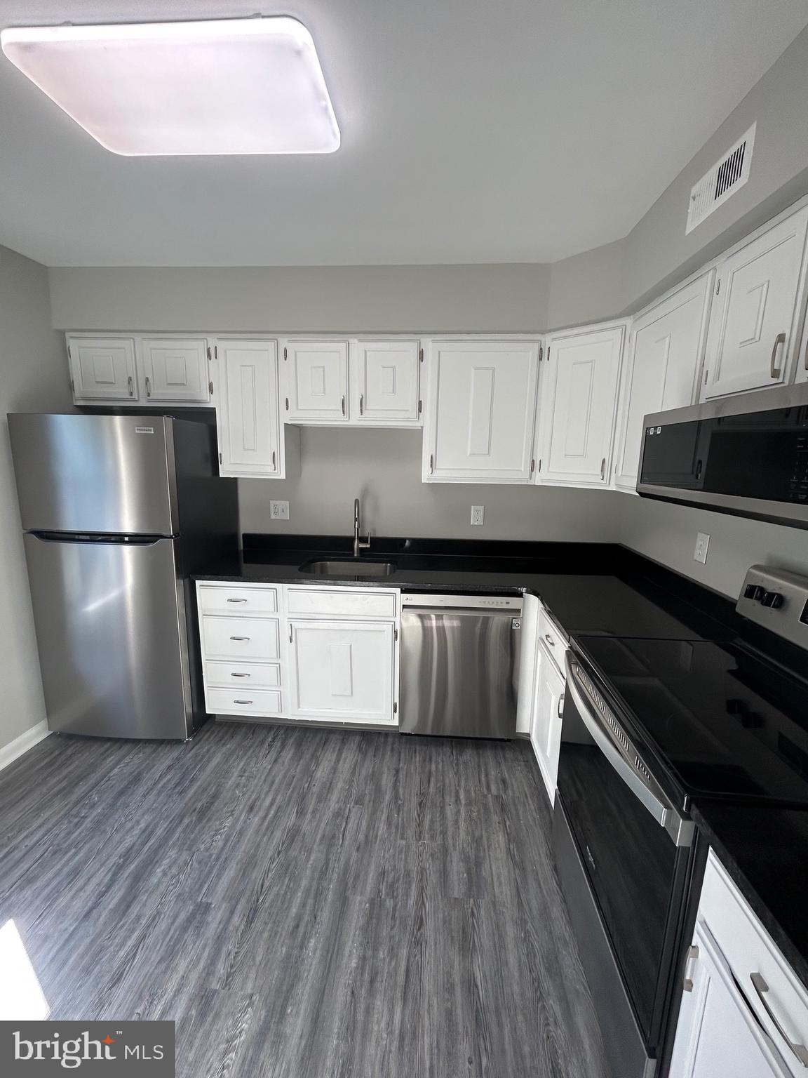 428 B Willow Turn Mount Laurel, NJ 08054 - Photo 3 of 16 a kitchen with a refrigerator a microwave a sink and cabinets