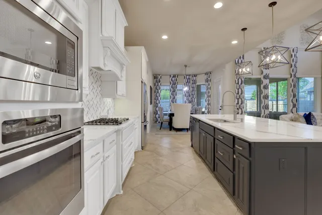 a large kitchen with stainless steel appliances a large counter space a sink and a stove