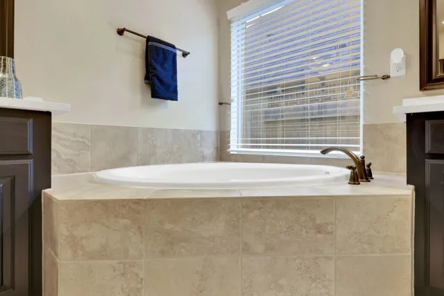 a bathroom with a tub sink shower and mirror