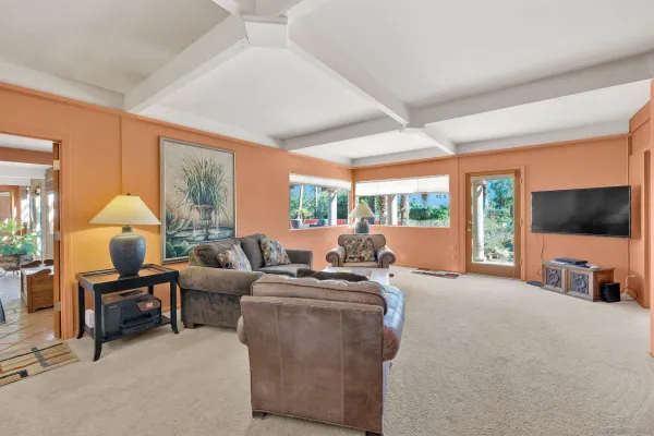 a living room with furniture a flat screen tv and a large window