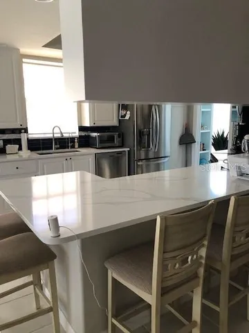 a kitchen with stainless steel appliances kitchen island a refrigerator sink and cabinets