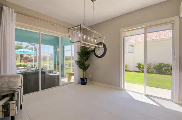 a view of an empty room with furniture and a chandelier