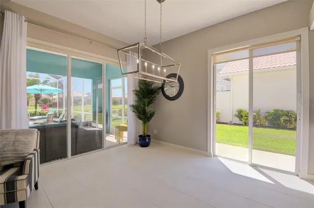 a view of an empty room with furniture and a chandelier