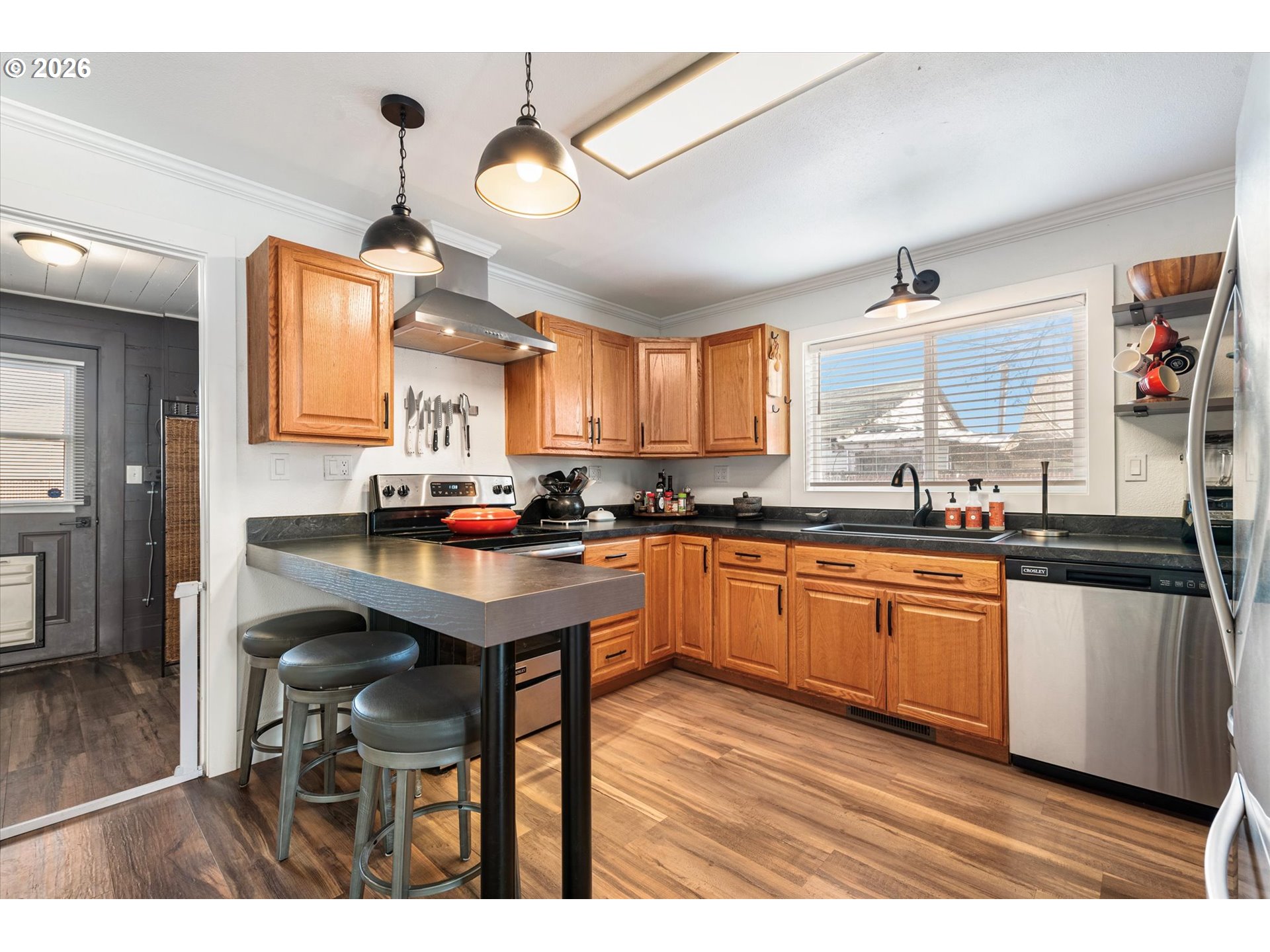 1660 Church Street Baker City, OR 97814 - Photo 11 of 25 a kitchen with granite countertop a table chairs a sink dishwasher refrigerator and cabinets