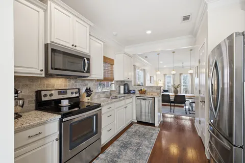 a kitchen with stainless steel appliances granite countertop a refrigerator stove microwave and sink