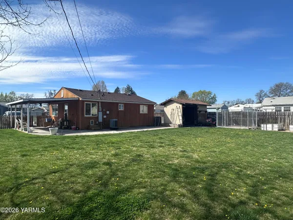 a view of a backyard with table and chairs and a barbeque