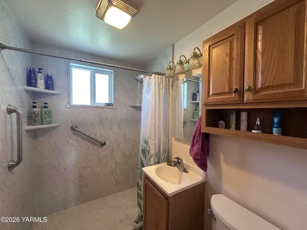 a bathroom with a sink a toilet and shower curtain