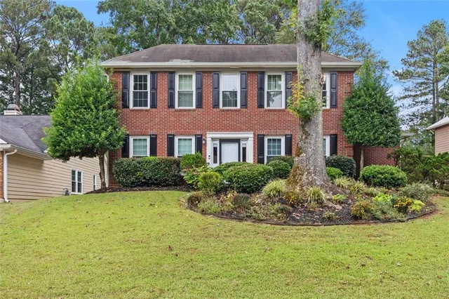 a front view of a house with yard and green space
